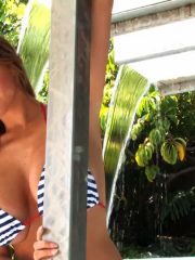 Gorgeous hottie with amazing juggs posing in striped bikini outdoor