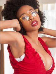 Ravishing ebony babe in glasses uncovering her massive boobs